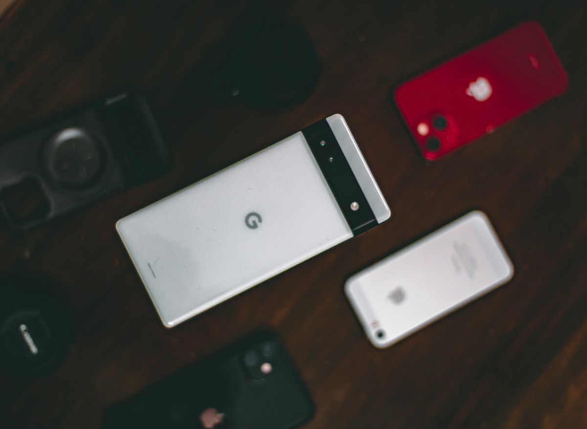 A group of different phones on a wooden table