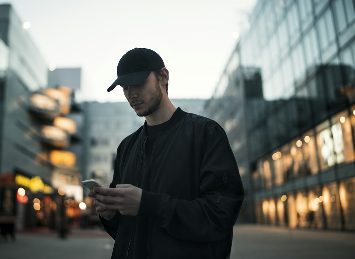 A man in a cap using a phone in the street