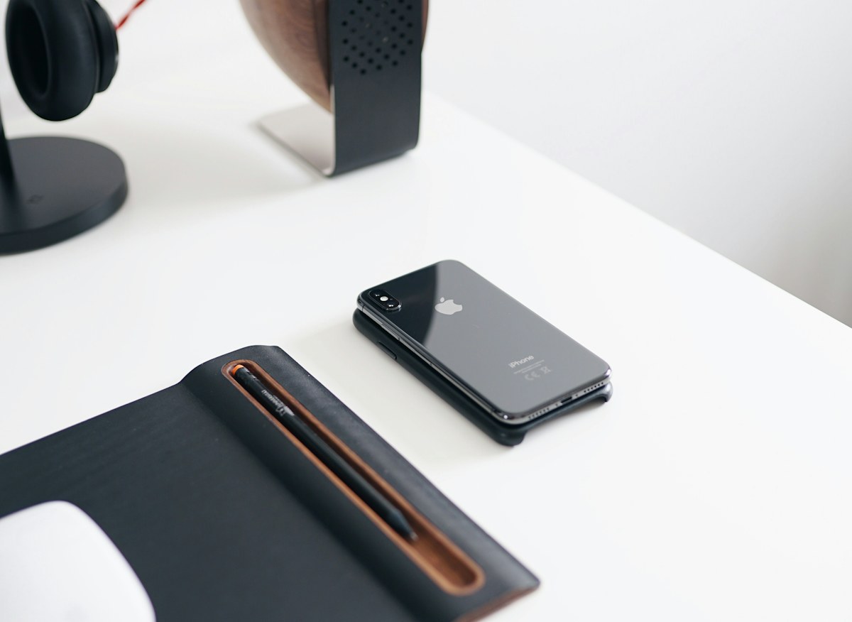 A phone lying on a desk beside a keyboard